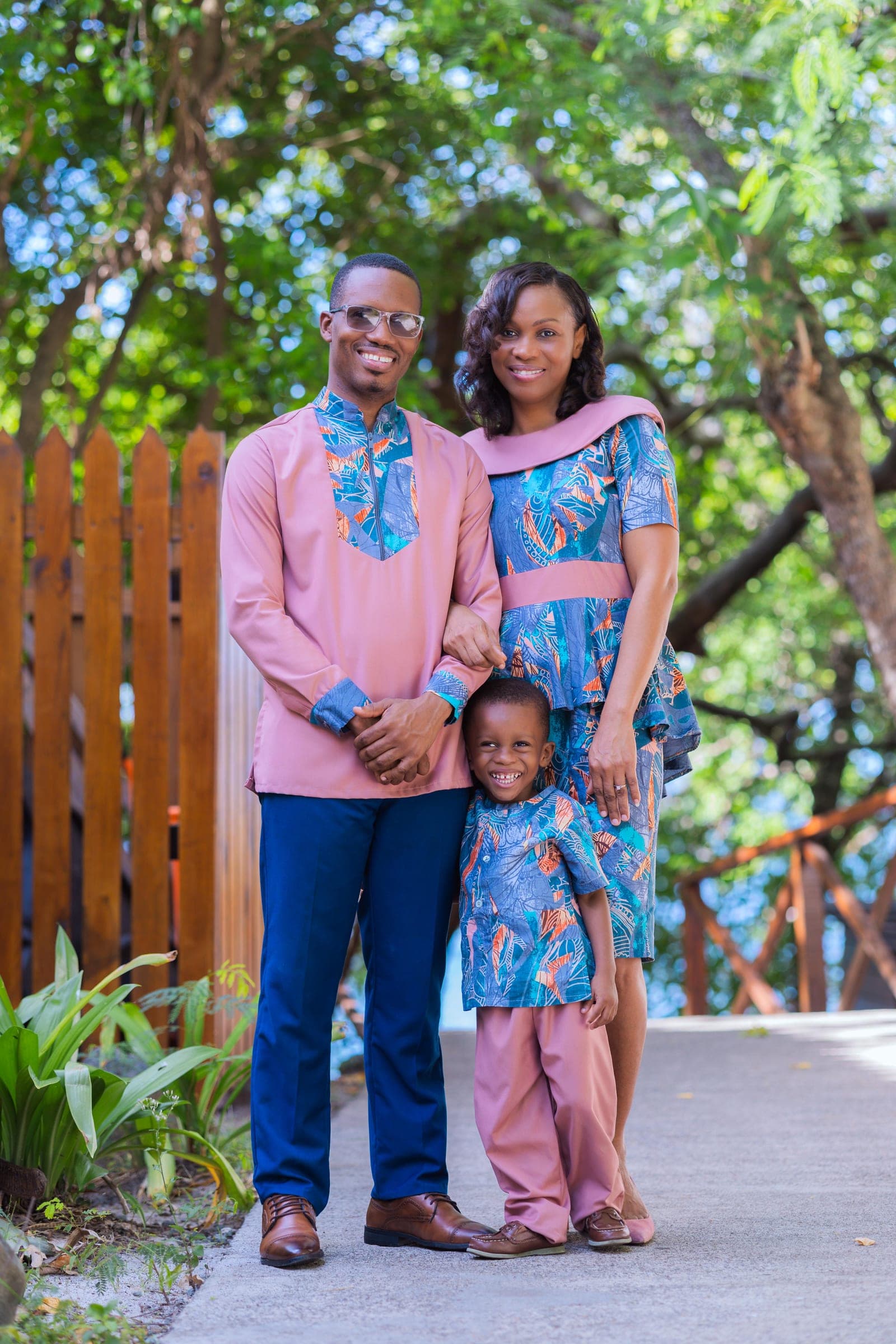 Pastor Travis C. Berance with his wife and son on a garden path in Virgin Gorda, the three of them in matching pink and blue